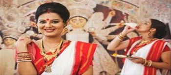 Women wear red border sarees on Durga Puja